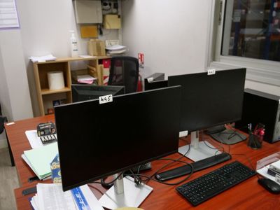 a desk with two monitors and a keyboard on it