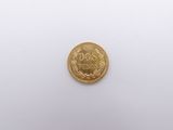 a close up of a gold coin on a white surface