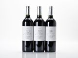 three bottles of wine sitting on top of a white table