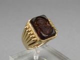 an image of a gold ring with a roman coin in the center