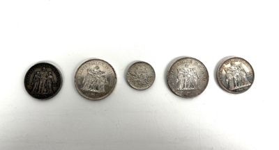 cinq pièces d'argent sont disposées en ligne sur une surface blanche
