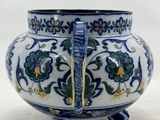 a blue and white vase with a handle on it