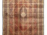 un tapis persan ancien, orné d'un motif en médaillon et de franges