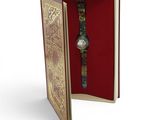 a book with a watch inside of it on a white surface