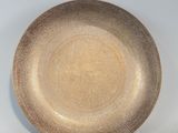 une assiette marron posée sur une table, sur fond blanc