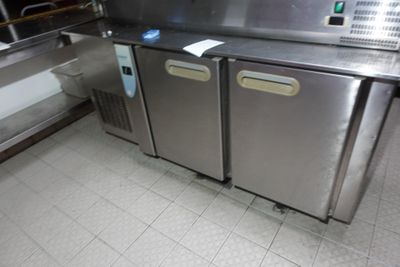 deux réfrigérateurs en acier inoxydable dans une cuisine au sol carrelé