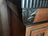 a wooden chest of drawers with a decorative design on it