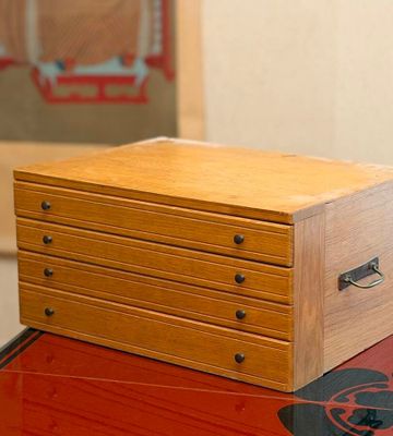 a small wooden box sitting on top of a red table