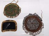 three small purses are displayed in a display case on a white surface