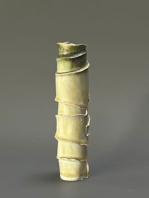 a small vase with a green decoration on it