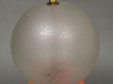 an orange table lamp with a glass ball on top of it