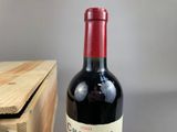 a bottle of wine sitting on a table next to a wooden box