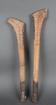 Deux grands bâtons en bois sont posés l'un à côté de l'autre sur une surface grise.