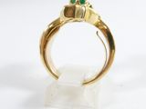 an image of a close up of a gold ring with a green stone