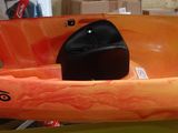 Des kayaks aux couleurs vives sont suspendus à un support dans un entrepôt