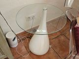 une table en verre sur laquelle est posé un vase blanc