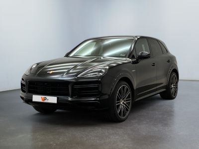 a black porsche cayen is parked in a white room