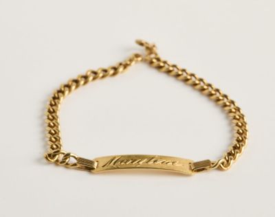un bracelet en or sur lequel est gravé un prénom