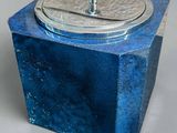 une petite boîte bleue avec un couvercle, posée sur une table