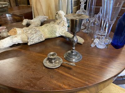 une table en bois sur laquelle sont posés des vases en verre et un bougeoir