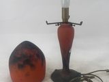 a lamp and an orange object on a white surface