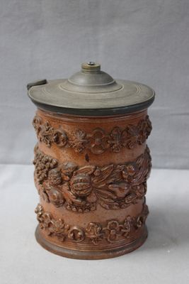 an old wooden canister with a metal lid sitting on a white surface