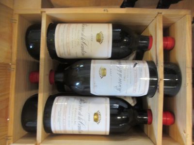 des bouteilles de vin se trouvent dans un coffret en bois sur une table