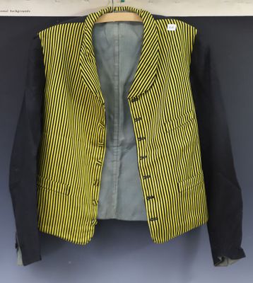 a yellow and black jacket hanging on a wall next to a blue wall