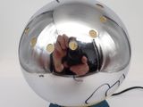 a person taking a picture of a silver object
