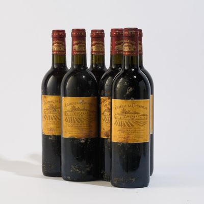 trois bouteilles de vin rouge sont alignées sur une surface blanche