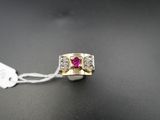 un gros plan d'une bague posée sur une surface noire, avec une étiquette