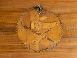 a wooden plaque with a picture of a man and a knife on it