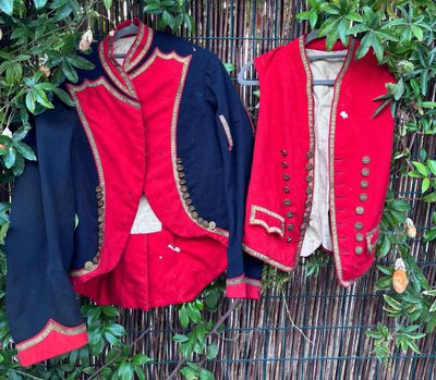 deux vestes accrochées à un mur, à côté d'un buisson