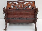 an antique wooden magazine rack with a carved design on the front