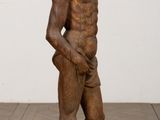 statue of a man standing on a pedestal with his hands in his pockets