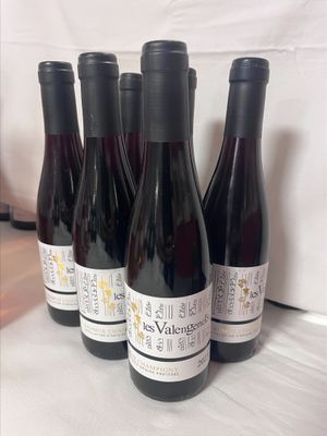 six bouteilles de vin sont alignées sur une table