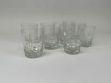 quatre verres à pied en verre transparent posés sur une table blanche