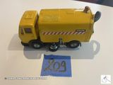 un petit camion jaune en plastique posé sur une table