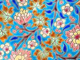 a close up of a colorful tile with flowers on it
