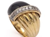 an image of a gold ring with a black stone and diamonds