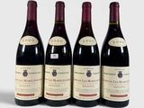 three bottles of red wine are lined up on a white surface