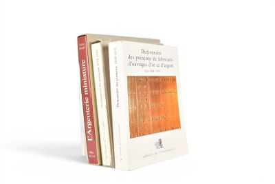 deux livres sont empilés l'un sur l'autre sur une surface blanche