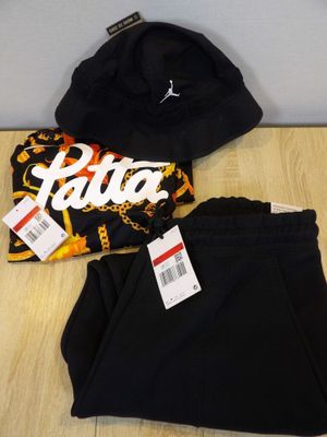 un pantalon noir et un chapeau posés sur une table