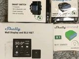 Trois boîtes contenant des appareils connectés sont posées sur une surface recouverte de moquette.