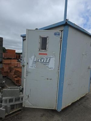 un petit bâtiment blanc au toit bleu, au bord de la route