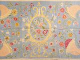 une photo d'un tapis bleu orné d'un motif floral