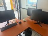 deux écrans d'ordinateur et un clavier posés sur le bureau