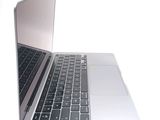 a silver laptop with a black keyboard on a white surface