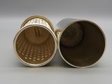 pair of silver and gold vases sitting on top of a white surface
