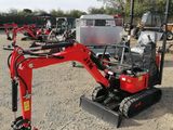 a small red excavator that is parked in the dirt